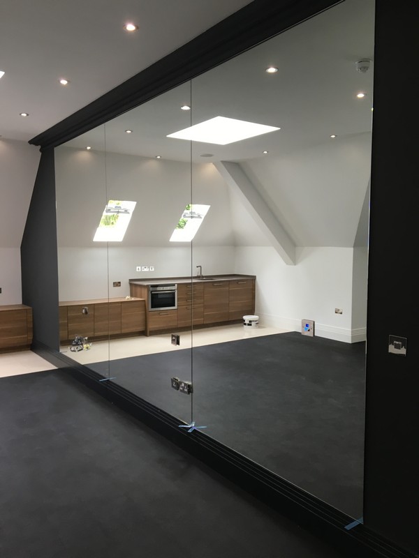 Frameless glass partition in loft conversion by Barnet glaziers